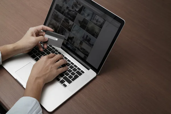 Vista superior das mãos usando laptop e segurando cartão de crédito com soci — Fotografia de Stock