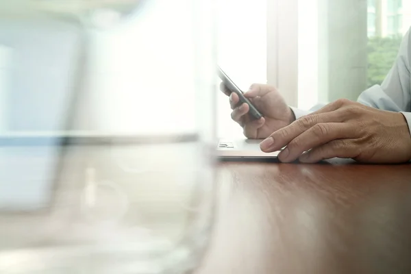 Business man hand working with mobile phone and laptop computer — Zdjęcie stockowe