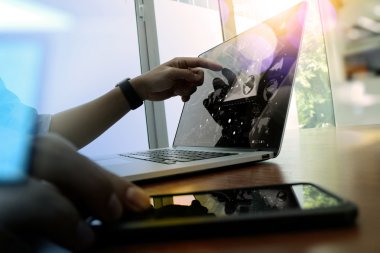 business man hand working on laptop computer on wooden desk wit