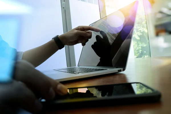 Designer hand working and smart phone and laptop on wooden desk — Stock Photo, Image