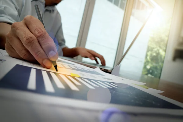 Business man hand working on laptop computer with business graph — Stock Photo, Image