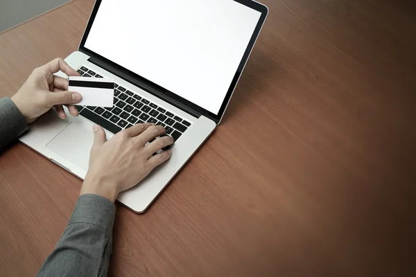 Vista superior das mãos usando laptop e segurando cartão de crédito com blan — Fotografia de Stock