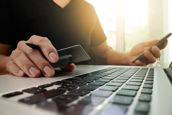 Mãos usando laptop e segurando cartão de crédito com mídia social dia — Fotografia de Stock