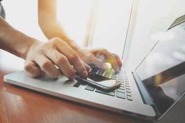Tasarımcı el çalışma ve akıllı telefon ve ahşap masa laptop 