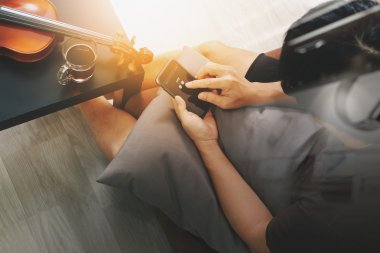 hipster hand composing music with smart phone and holding a cup 