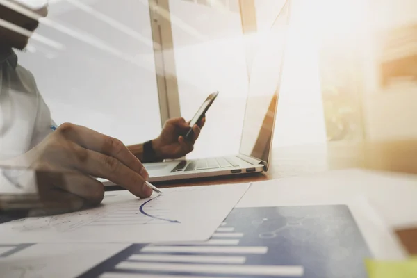 Business documents on office table with laptop computer and grap — Stock Photo, Image