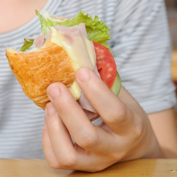 Kvinna med skinka och ost croissant — Stockfoto