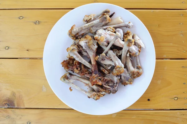 Chicken bones in white plate — Stock Photo, Image