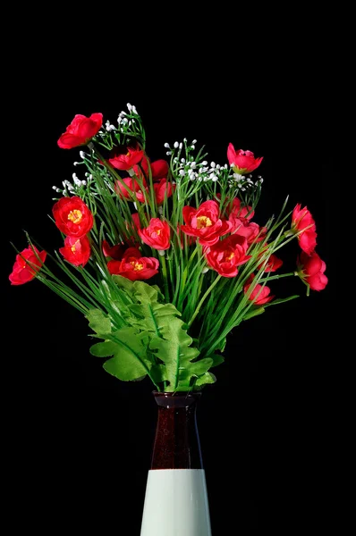Flores rojas artificiales en jarrón — Foto de Stock
