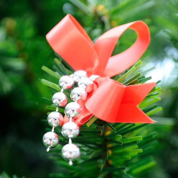 Red ribbon on green tree. — Stock Photo, Image