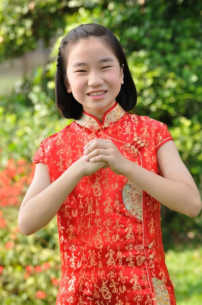 Asia femmina adolescente indossare abito rosso posa per scattare foto in giardino — Foto Stock