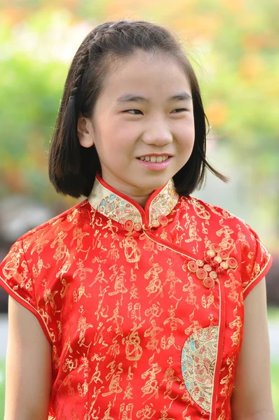 Asia femmina adolescente indossare abito rosso posa per scattare foto in giardino — Foto Stock