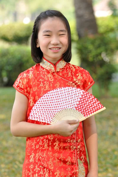 Asia femmina adolescente indossare abito rosso e tenere un ventilatore di carta in garde — Foto Stock