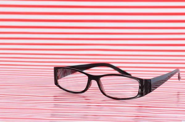 Black glasses on red texture — Stock Photo, Image