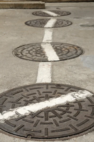 Alcantarillas cubiertas en la calle — Foto de Stock