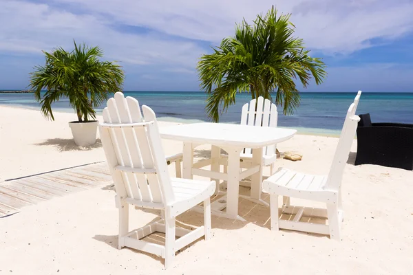 Restaurang bord och stolar på stranden — Stockfoto