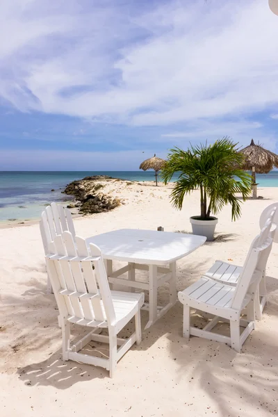 Vit restaurangbord och stolar på stranden — Stockfoto