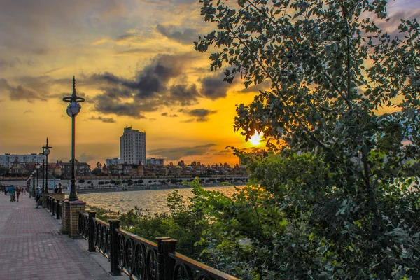 Gelber Sonnenuntergang am Ufer des Flusses in der Stadt — Stockfoto