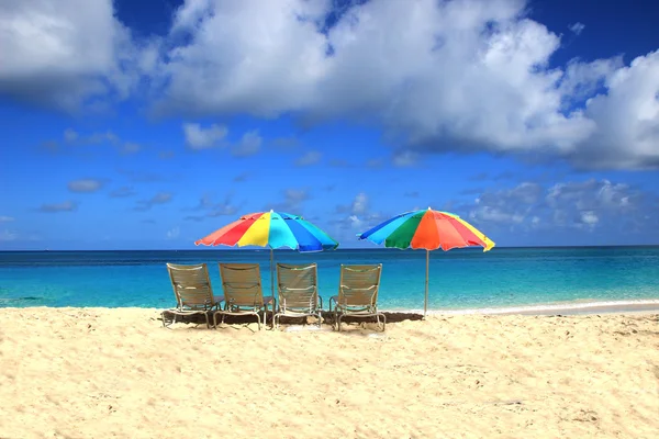 Schöne Liegestühle und Sonnenschirme am sonnigen Strand der Karibik — Stockfoto