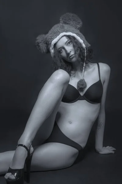 Σέξι Μοντέλο Κάθεται Πάνω Από Ένα Σκούρο Φόντο Εσώρουχα Και — Φωτογραφία Αρχείου