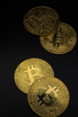 Bitcoins yumuşak ışıkta dizüstü bilgisayarda yatıyor