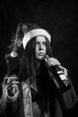Siyah arka planda sigara içen Noel Baba kostümlü seksi kız.