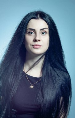 Gri arka planda duran siyah elbiseli sevimli gotik kız.