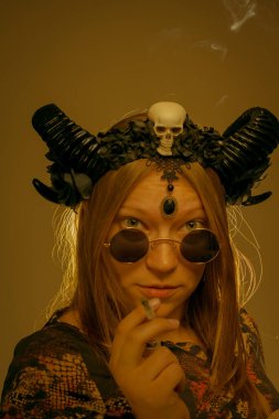 Yeşil üzerine sigara içen acımasız boynuzlu kız.