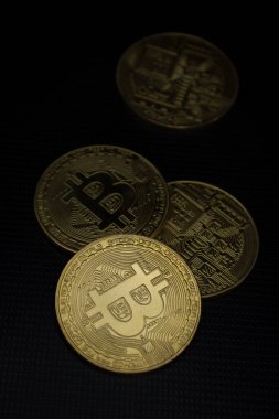 Bitcoins yumuşak ışıkta siyah bir yüzey üzerinde yatıyor