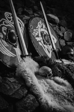 Kayalık nehir kıyısında Viking kalkanları ve kılıçları