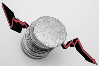 Beyaz zemin üzerinde kırmızı ok olan bitcoin yığını. Bitcoin konseptinin düşüşü.