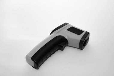 Beyaz zemin üzerindeki sıcaklığı ölçmek için kızılötesi termometre (termometre). Covid-19 yayılma önleme kavramı. 