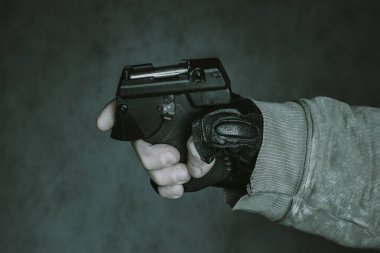 Nefsi müdafaa silahı elinde. Siyah arka planda biber gazı tabancası..