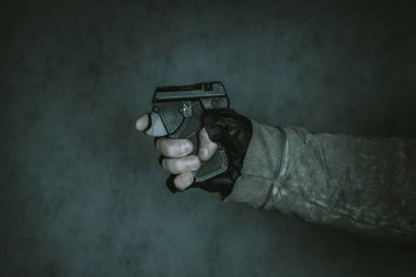Nefsi müdafaa silahı elinde. Siyah arka planda biber gazı tabancası..