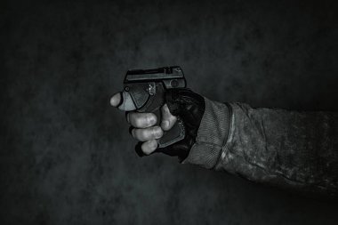 Nefsi müdafaa silahı elinde. Siyah arka planda biber gazı tabancası..