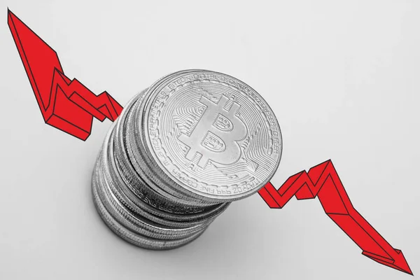 stock image Stack of bitcoins with red arrow over white background. Fall of bitcoin concept.