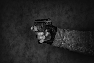 Nefsi müdafaa silahı elinde. Siyah arka planda biber gazı tabancası..