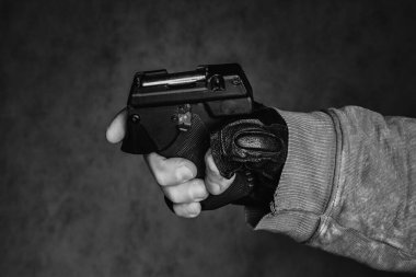 Nefsi müdafaa silahı elinde. Siyah arka planda biber gazı tabancası..