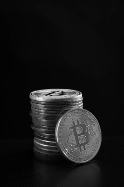 Bir gümüş bitcoin ve arka planda bir yığın bitcoin