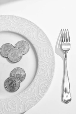 Beyaz arkaplan üzerine çatal ve bitcoin içeren plaka