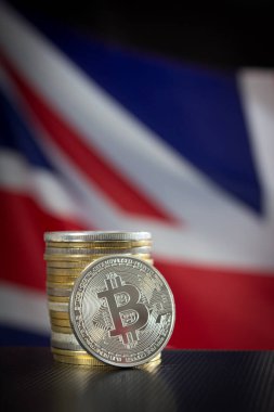 Birleşik Krallık bayrağı üzerinde bitcoin yığını. Bitcoin 'lere odaklan.