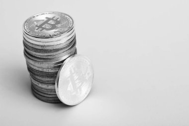 Sarı zemin üzerinde bir bitcoin ve bir yığın bitcoin