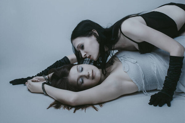 Две сексуальные девушки позируют на белом фоне