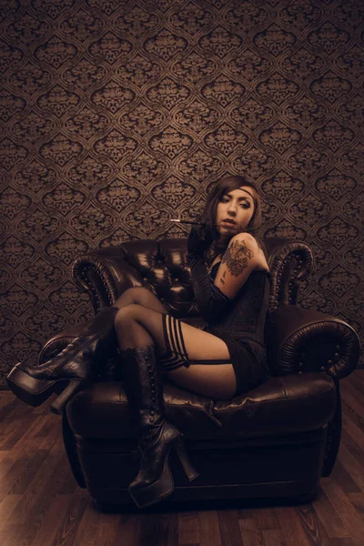 Koltuğunda oturan eski moda bir kadın.