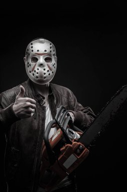 koyu arka plan üzerinde poz chainsaw ile maskeli adam