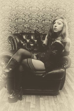 Koltuğunda oturan eski moda bir kadın.