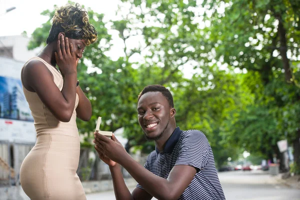 Junger Mann Kniet Einem Park Und Schenkt Seiner Freundin Lächelnd — Stockfoto