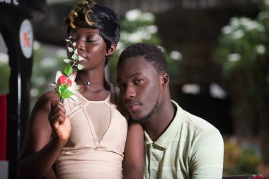 Sevgililer Günü evlenme teklifi konsepti. Dışarıda oturan neşeli romantik bir çift. Genç çift parkta aşktan zevk alıyor..