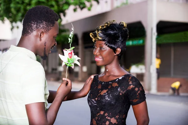 Junger Mann Shirt Der Lächelnd Seiner Freundin Eine Blume Überreicht — Stockfoto