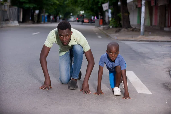 Young family promoting a healthy lifestyle. Man and son run and have fun on the road.